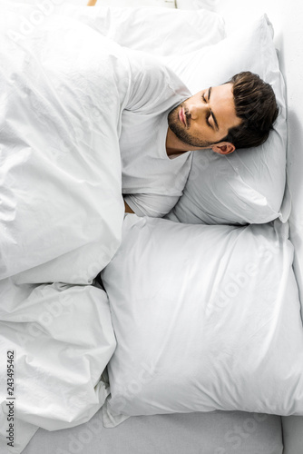 top view of handsome man sleeping in bed in the morning