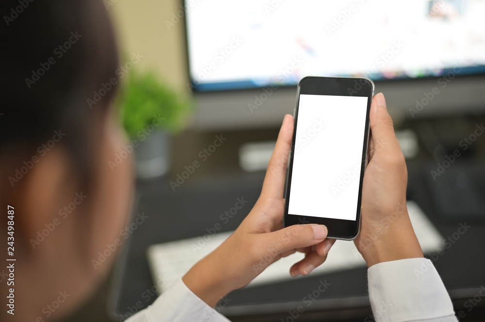 Mockup smartphone on female hands empty display on office table with blur background. - Image