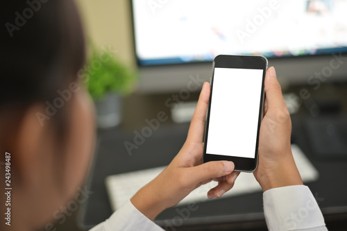 Mockup smartphone on female hands empty display on office table with blur background. - Image
