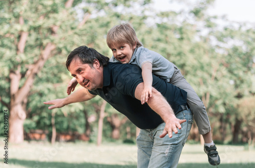 dad plays with his little son on a walk in the Park .
