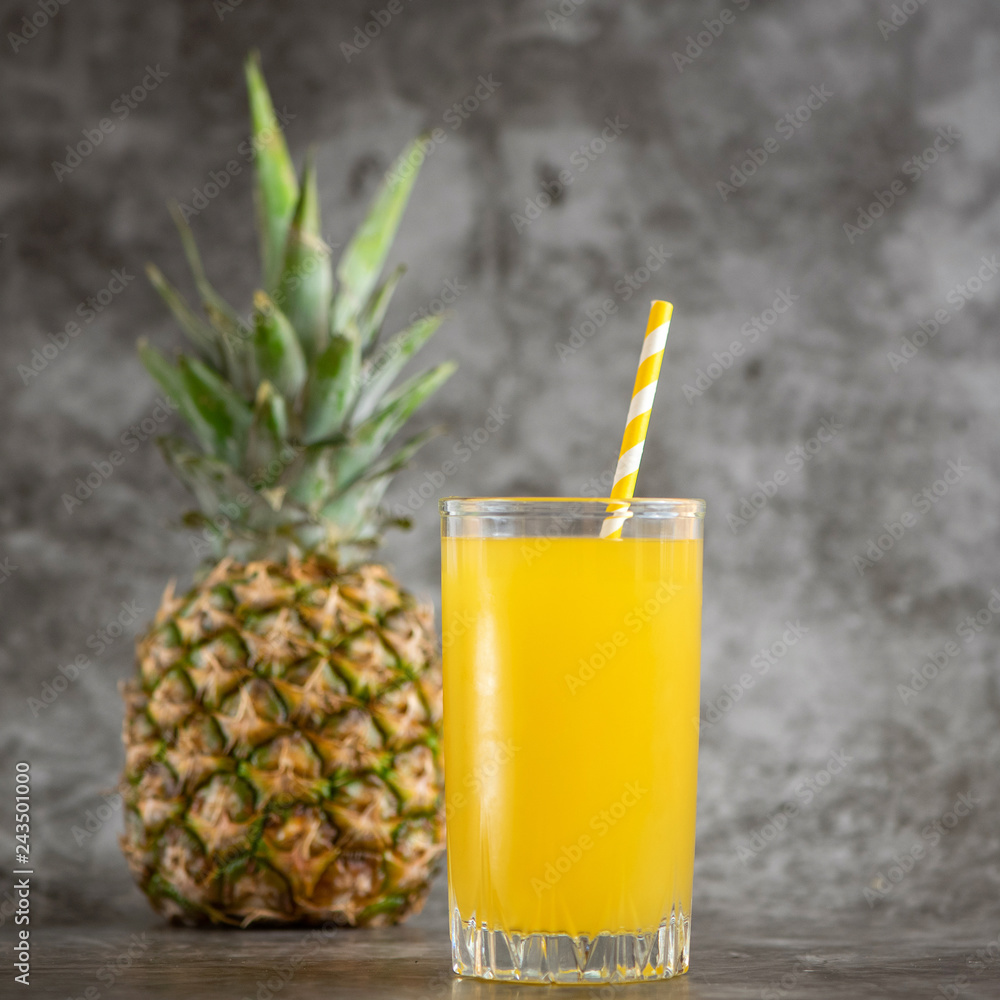 glass of pineapple juice with fresh fruits on grey bacground glass of pineapple juice with fresh fruits on grey bacground