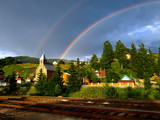 Twin rainbow over Carpathian mountain village. Eastern Carpathians, Ukraine