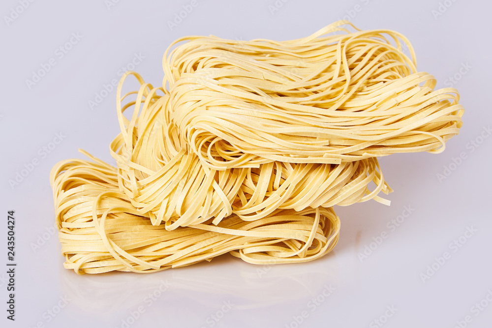 Dry thin rolled noodles square shape. Capelli d'angelo, Angel's hair - pasta.  Homemade italian pasta tagliatelle. Italian Cuisine. Egg noodles. Pasta tagliatelle nest isolated on white background