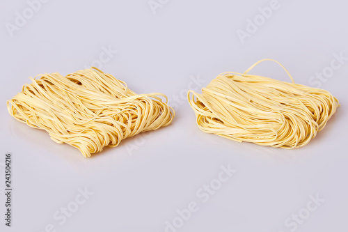 Dry thin rolled noodles square shape. Capelli d'angelo, Angel's hair - pasta.  Homemade italian pasta tagliatelle. Italian Cuisine. Egg noodles. Pasta tagliatelle nest isolated on white background
