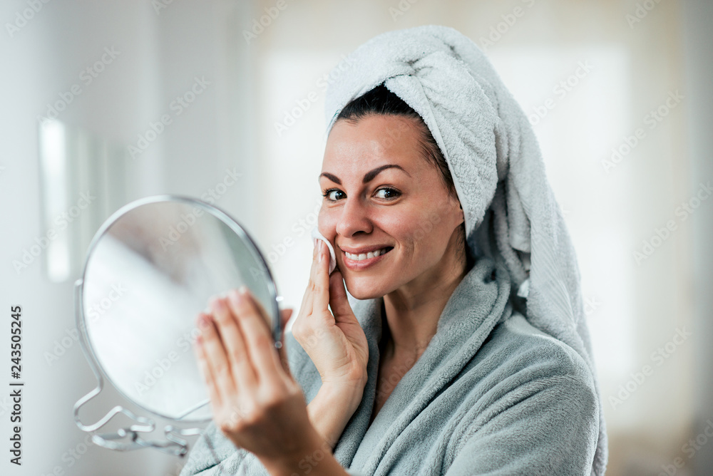 Skincare and beauty concept. Smiling woman cleaning face with cotton pad. Skincare and beauty concept. Smiling woman cleaning face with cotton pad.