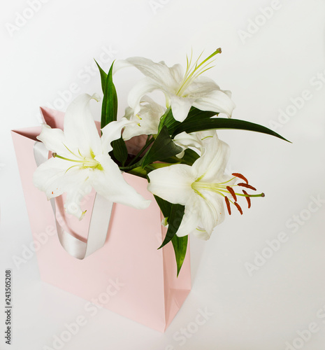 Fototapeta Naklejka Na Ścianę i Meble -  a bouquet of white lilies in a pink package 