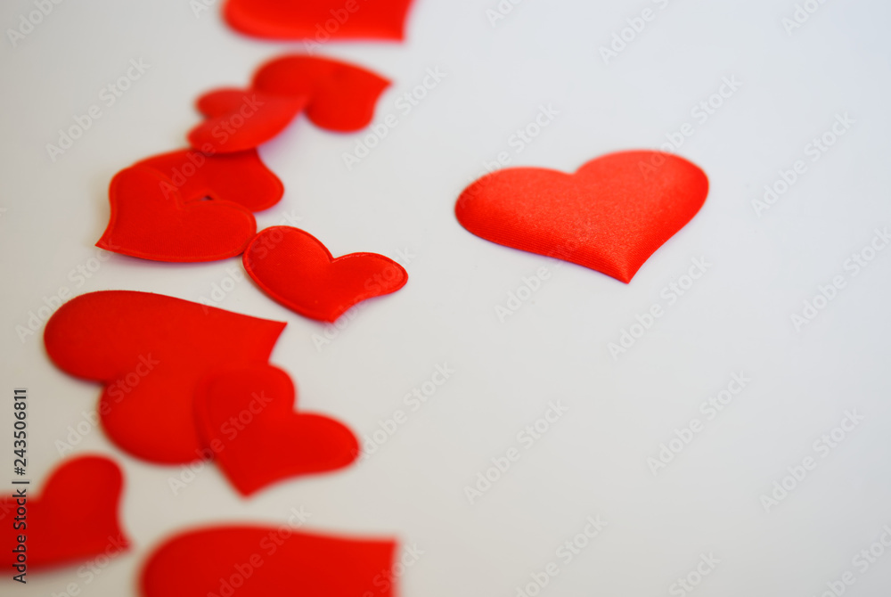 Red hearts lie on a white background. Free space to write congratulations on Valentine's Day