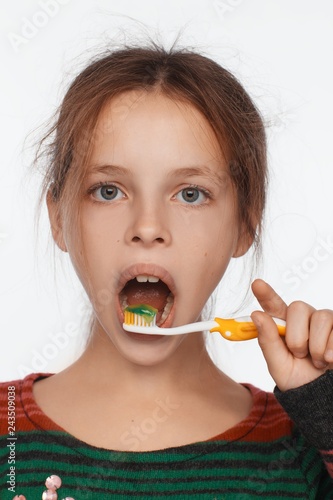 Portrait of an eight-year-old girl who brushes her teeth with a toothbrush