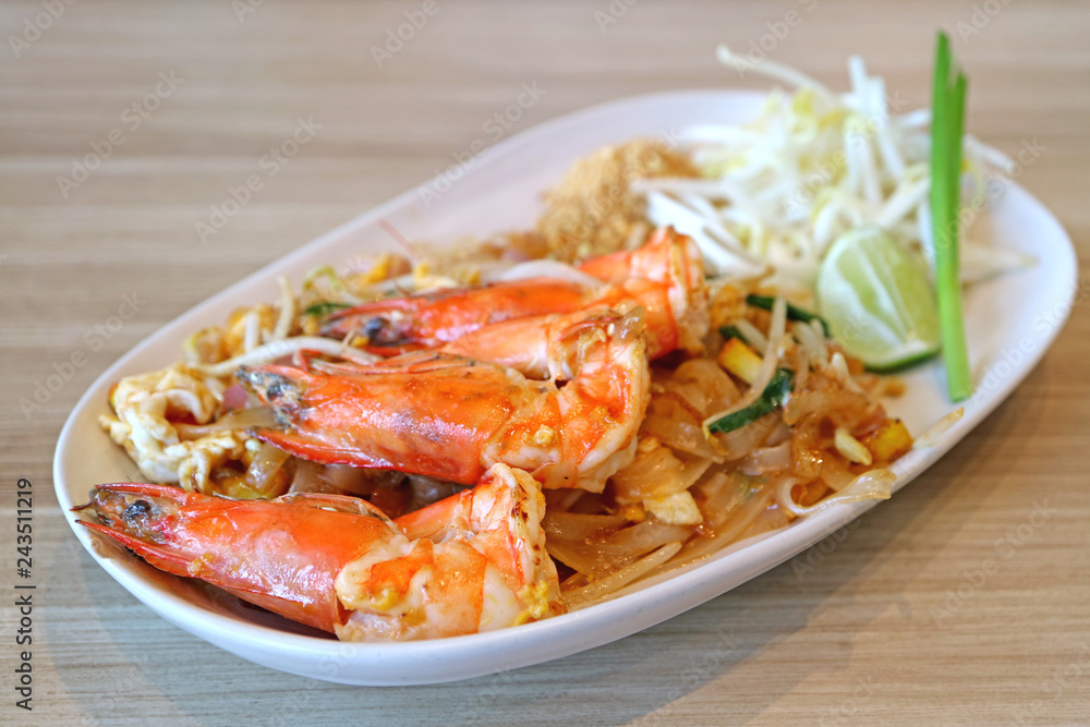 Closed Up Delectable River Prawns Topped on Pad Thai or Thai Style Fried Noodle Served on Wooden Table 