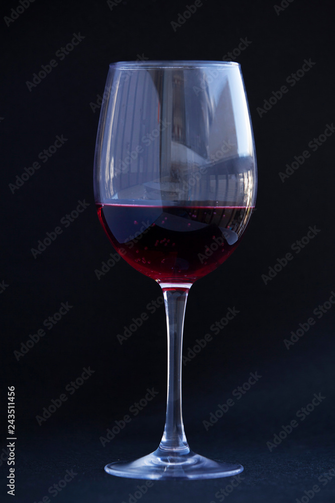 Crystal clear wine glass with traditional round goblet shape filled with dark red wine. Crystal clear wine glass with traditional round goblet shape filled with dark red wine.