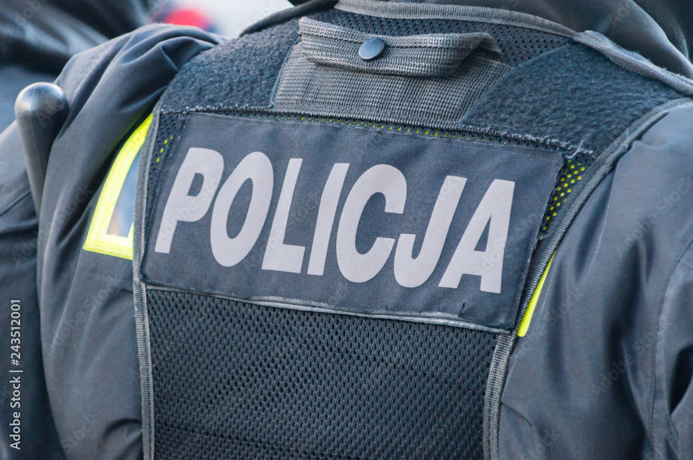 Back of polish policeman and inscription policja