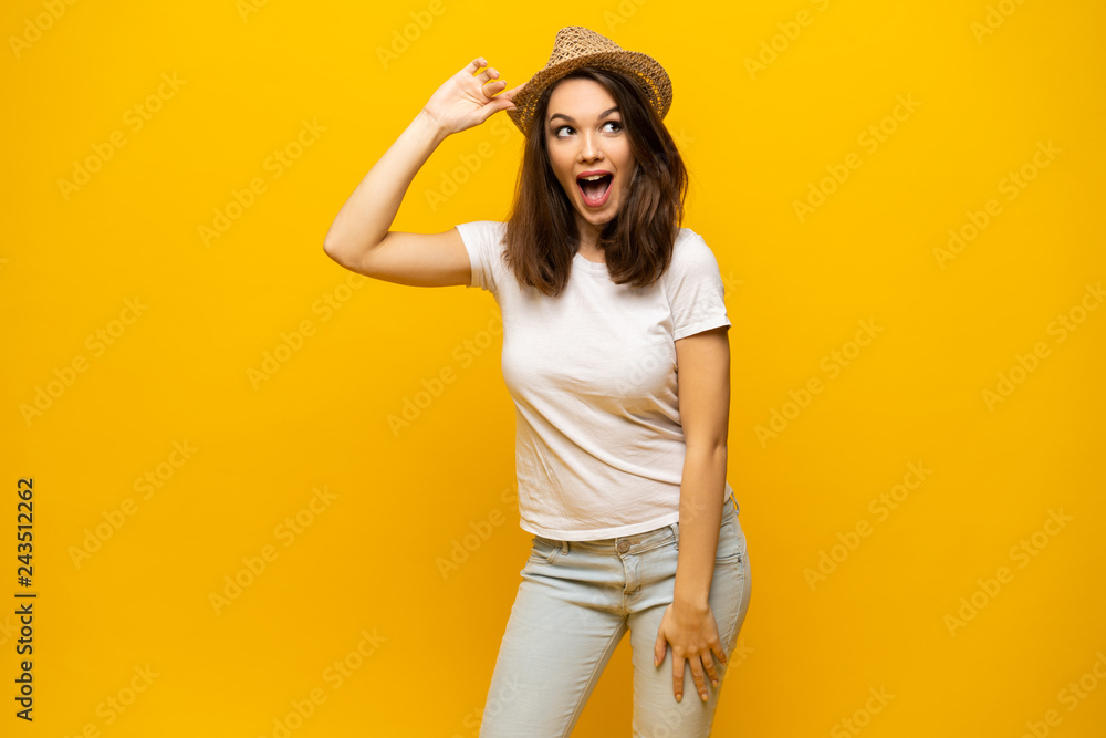 Excited young woman in white t-shirt, widely smiling, looking at camera. Isolated on yellow background Excited young woman in white t-shirt, widely smiling, looking at camera. Isolated on yellow background