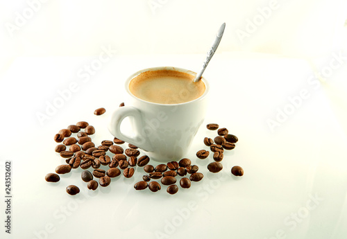 Coffee beans around a coffee cup with espresso coffee on a white background