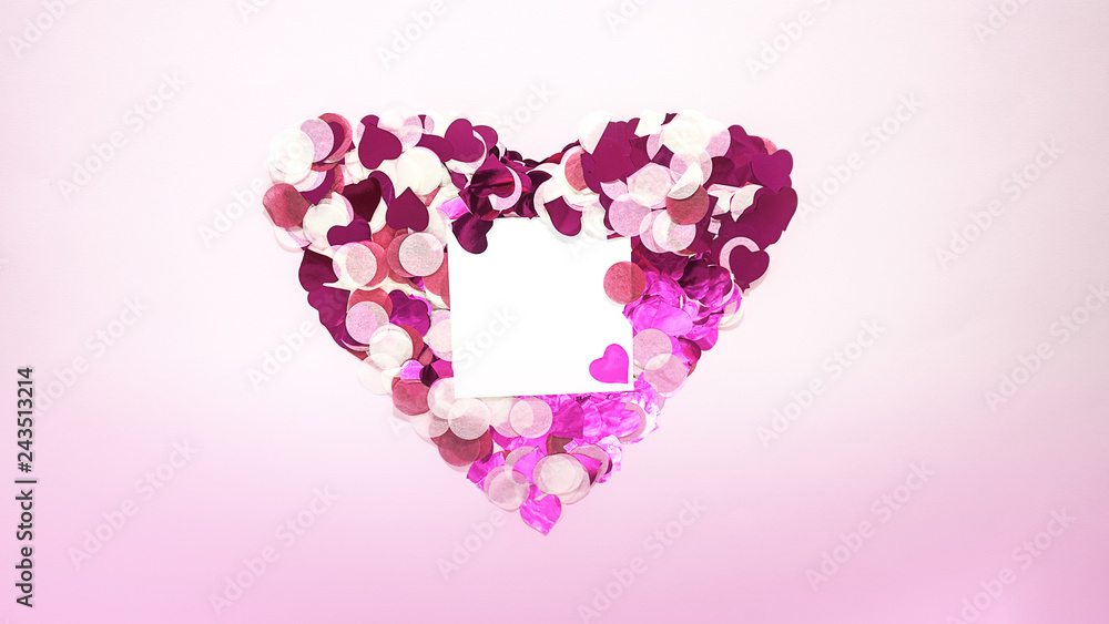 Valentines Day Heart shape made of pink glitter hearts with copy space paper card note on pastel Background. Valentine's day concept romantic celebration, wedding. Flat lay, horizontal. Love concept.