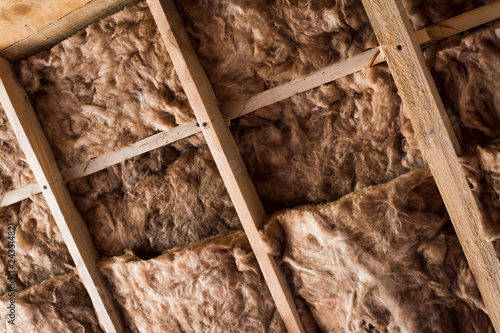 Bilde på lerret Glass wool in a wooden frame on a inclined wall near the wooden ceiling in a private house