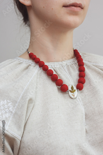 Red necklace with a pendant of felt wool on girl model