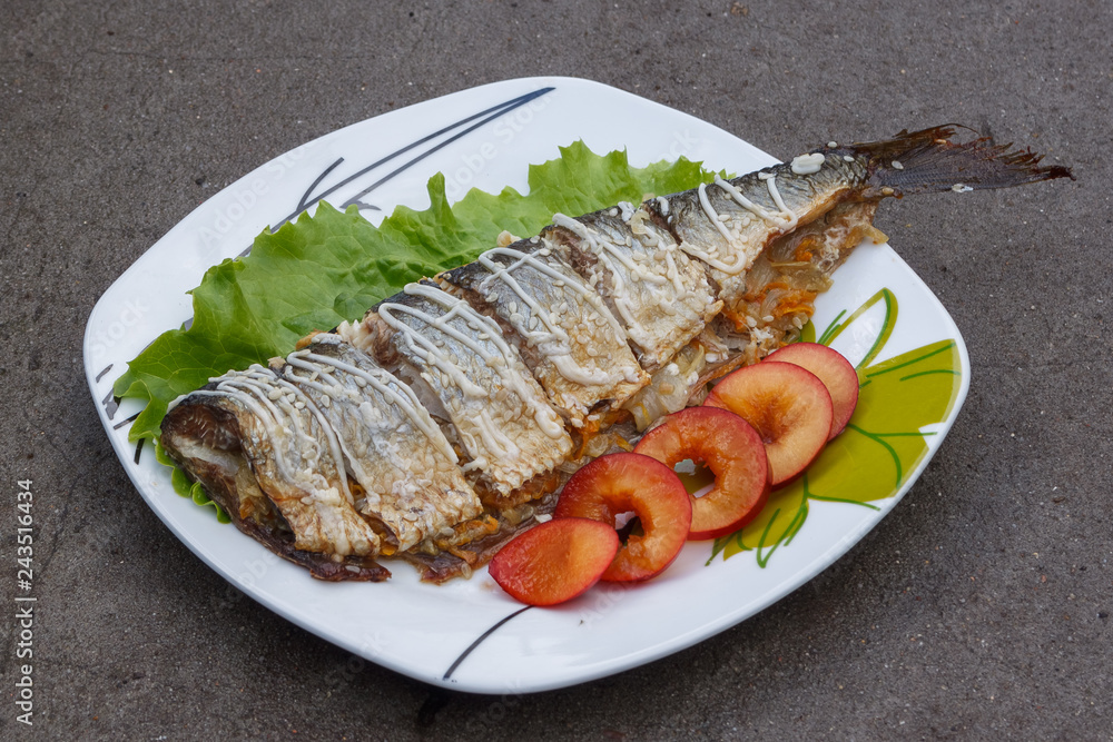 Baked mackerel with green lettuce and fruit. Close-up Baked mackerel with green lettuce and fruit. Close-up