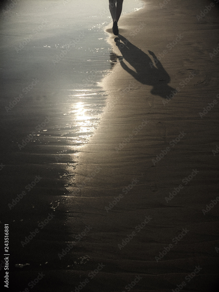 Centro de niños Organizar Matón Sombra de mujer caminando en la orilla del mar. Playa arena y luz del sol.  Stock Photo | Adobe Stock