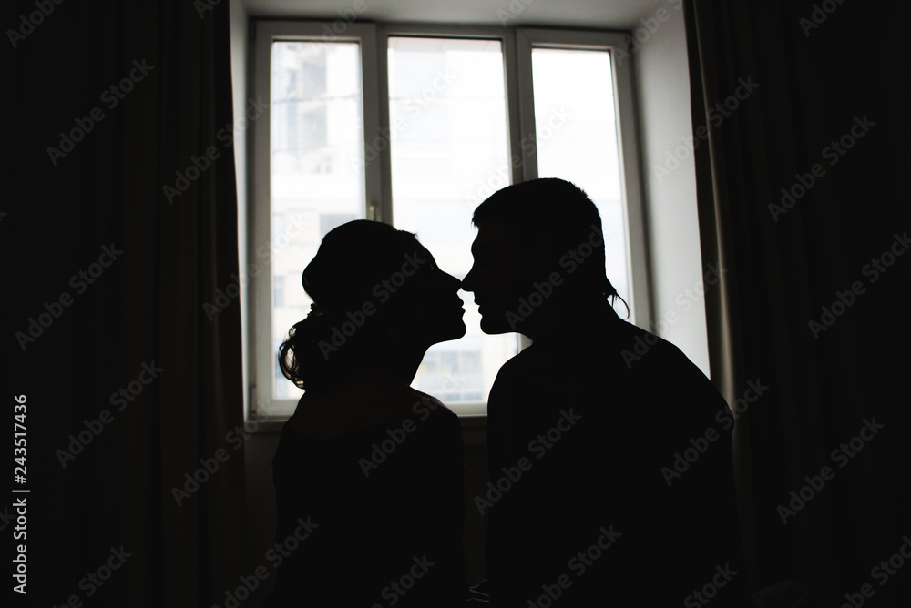 Romantic silhouettes of a couple in love against the window