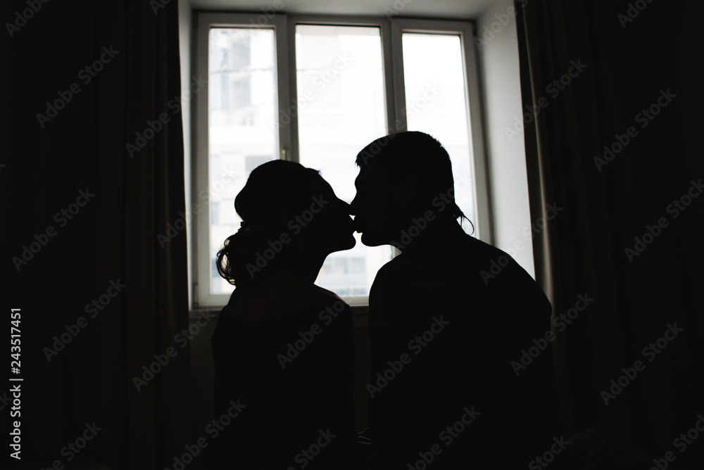 Romantic silhouettes of a couple in love against the window