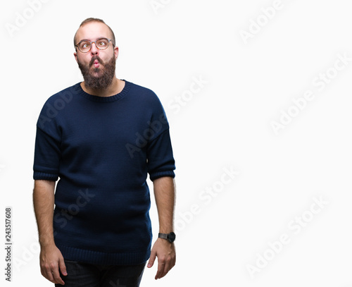 Young caucasian hipster man wearing sunglasses over isolated background making fish face with lips, crazy and comical gesture. Funny expression.