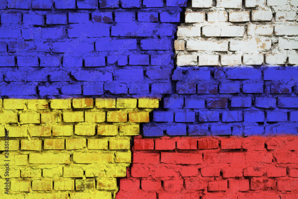 Flags of Ukraine and Russia on the brick wall with big crack in the middle. Symbol of problems between countries Flags of Ukraine and Russia on the brick wall with big crack in the middle. Symbol of problems between countries