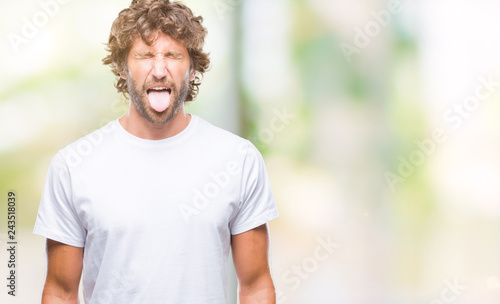 Handsome hispanic model man over isolated background sticking tongue out happy with funny expression. Emotion concept.