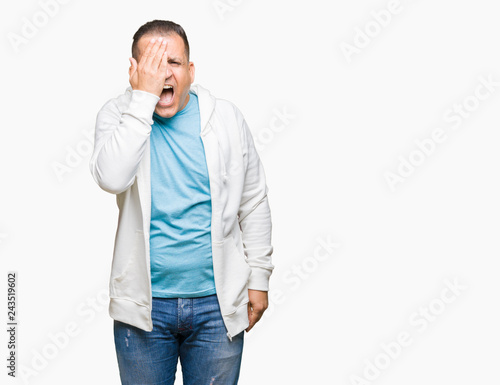 Middle age arab man wearing sweatshirt over isolated background covering one eye with hand with confident smile on face and surprise emotion.