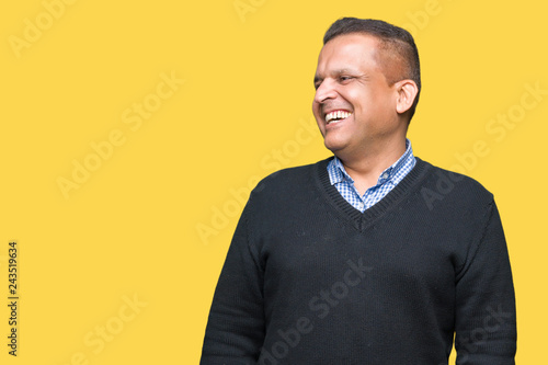 Handsome middle age man over isolated background looking away to side with smile on face, natural expression. Laughing confident.