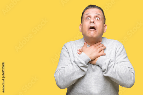 Middle age arab man wearing sport sweatshirt over isolated background shouting and suffocate because painful strangle. Health problem. Asphyxiate and suicide concept.