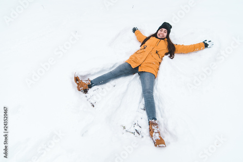 young adult woman making snow angel
