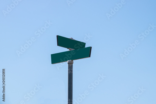 Картината върху платно Blank green street signs on metal post with blue sky background