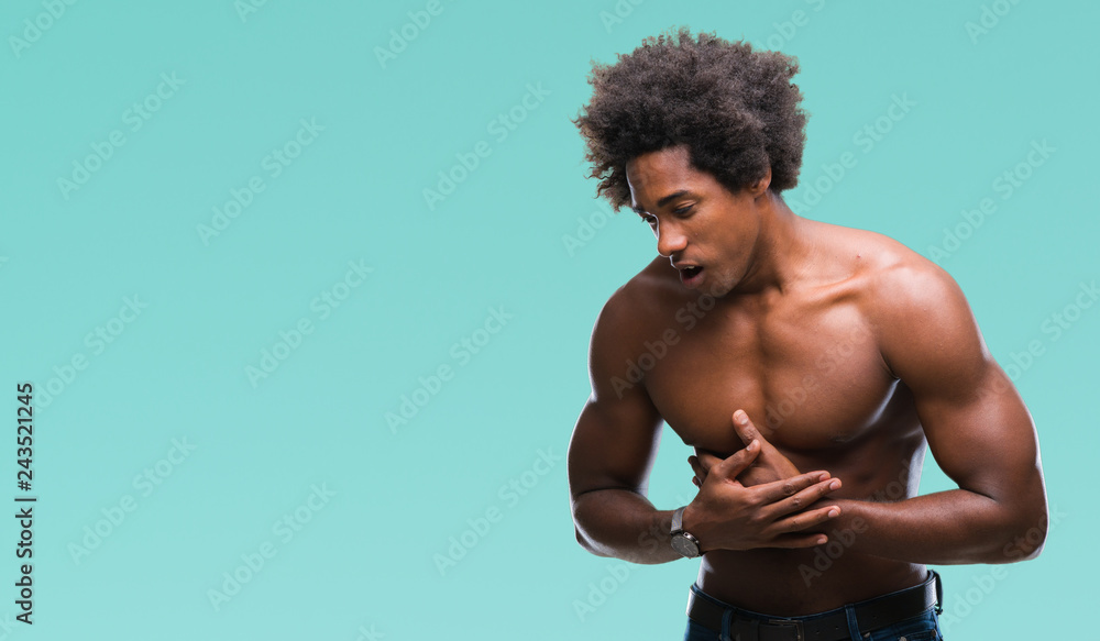 Afro american shirtless man showing nude body over isolated background with hand on stomach because indigestion, painful illness feeling unwell. Ache concept. Afro american shirtless man showing nude body over isolated background with hand on stomach because indigestion, painful illness feeling unwell. Ache concept.