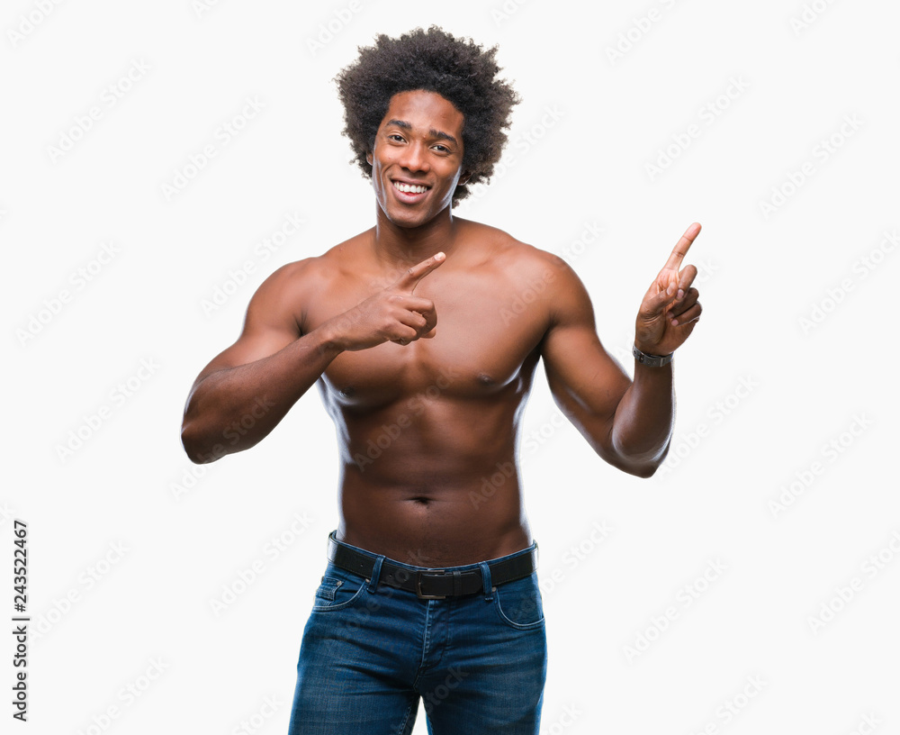 Afro american shirtless man showing nude body over isolated background smiling and looking at the camera pointing with two hands and fingers to the side. Afro american shirtless man showing nude body over isolated background smiling and looking at the camera pointing with two hands and fingers to the side.