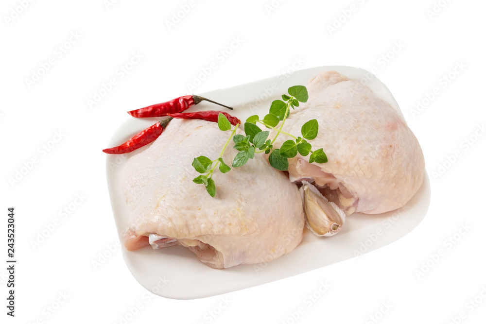 Raw chicken thighs with thyme on cutting board, on a white background. Raw chicken thighs with thyme on cutting board, on a white background.