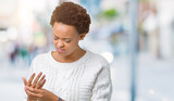 Beautiful young african american woman wearing sweater over isolated background Suffering pain on hands and fingers, arthritis inflammation