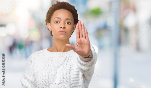 Wallpaper Mural Beautiful young african american woman wearing sweater over isolated background doing stop sing with palm of the hand. Warning expression with negative and serious gesture on the face. Torontodigital.ca