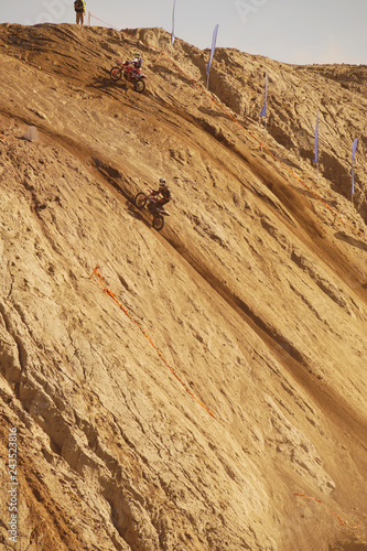 Motorcycle competition, steep climb to a high hill, two competitors.