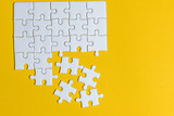 Jigsaw puzzles placed on a yellow background Creative concept with copy space