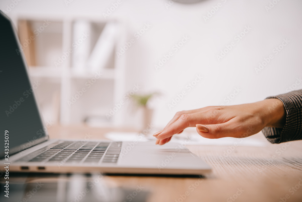 cropped view of businesswoman typing on laptop at workplace cropped view of businesswoman typing on laptop at workplace