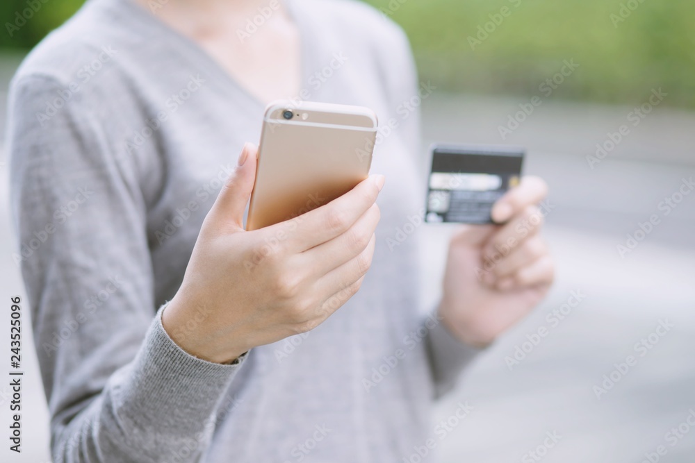 close up young female hands holding credit card and using mobile smart phone. Online shopping purchase Sell or Payment. Technology Pay online finance concept. close up young female hands holding credit card and using mobile smart phone. Online shopping purchase Sell or Payment. Technology Pay online finance concept.