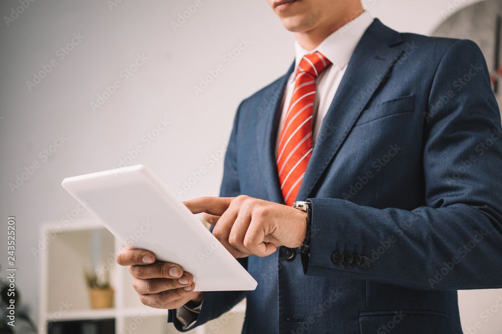 cropped view of businessman using digital tablet in office cropped view of businessman using digital tablet in office