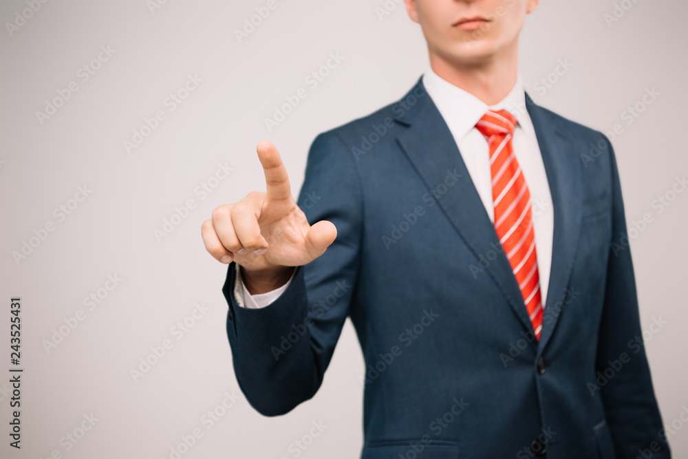 cropped view of businessman in suit pointing at something isolated on grey cropped view of businessman in suit pointing at something isolated on grey