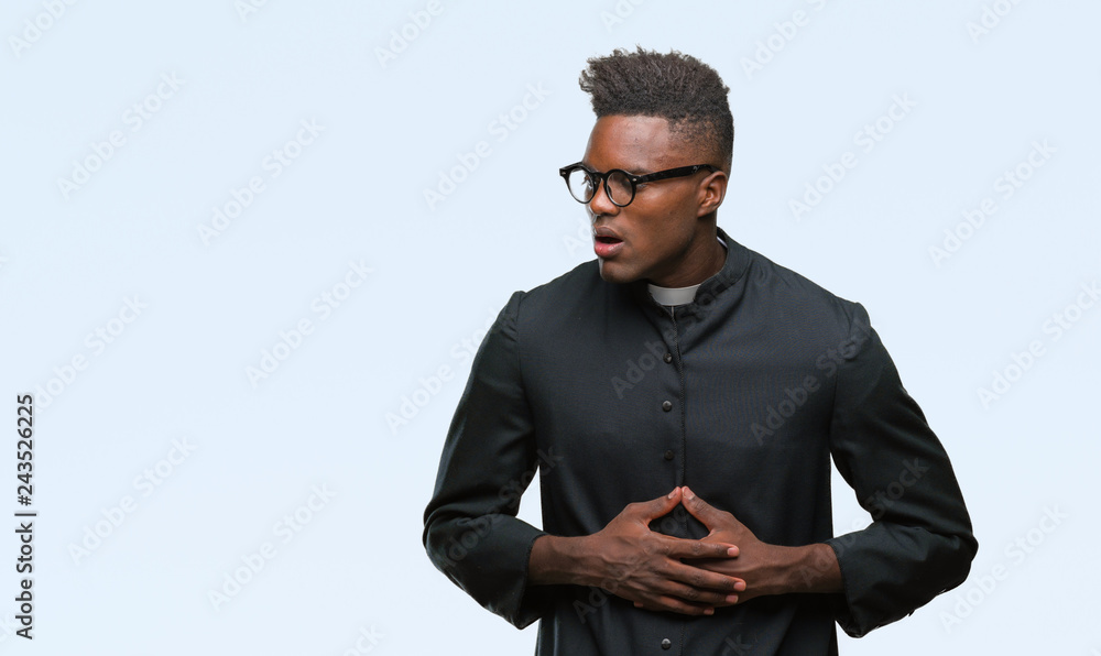 Young african american priest man over isolated background with hand on stomach because indigestion, painful illness feeling unwell. Ache concept. Young african american priest man over isolated background with hand on stomach because indigestion, painful illness feeling unwell. Ache concept.