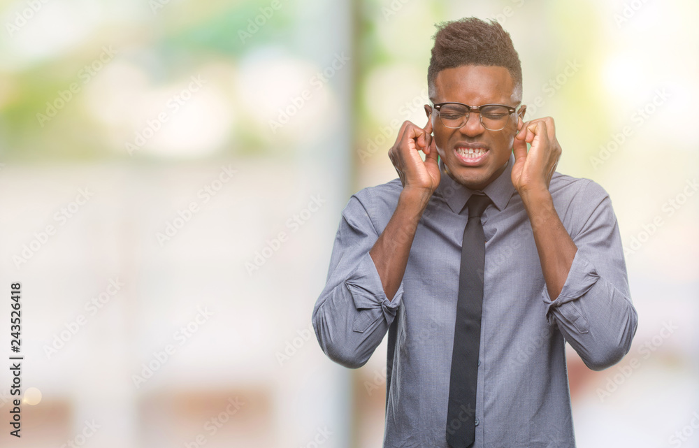 Young african american business man over isolated background covering ears with fingers with annoyed expression for the noise of loud music. Deaf concept. Young african american business man over isolated background covering ears with fingers with annoyed expression for the noise of loud music. Deaf concept.