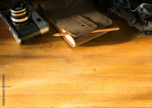 Konstfotografi traveler blog background; vintage camera and notebook on old office desk