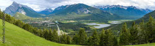 Banff - A panoramic overview of Town of Banff and Vermilion Lakes, surrounded by dense evergreen forest and high mountain peaks, on a cloudy Spring evening in Banff National Park, AB, Canada.