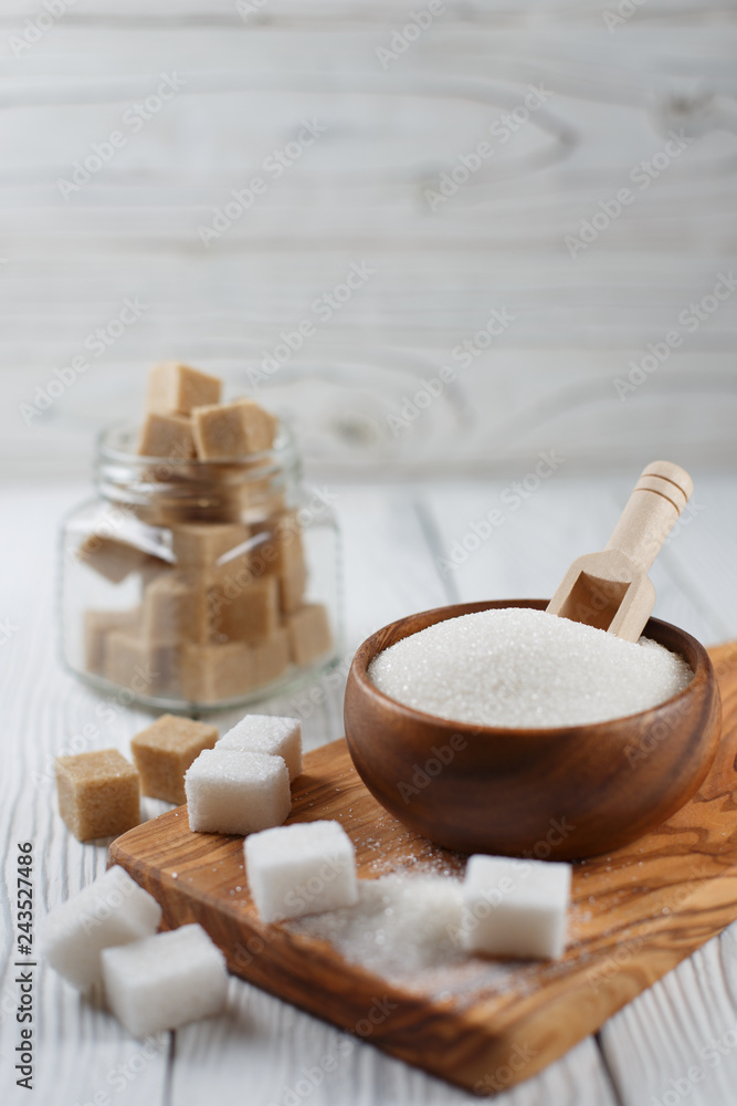 Wooden bowl with sugar on a wooden plank on a white table Wooden bowl with sugar on a wooden plank on a white table