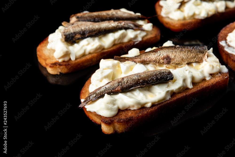 Sandwich with sprats, eggs and mayonnaise on black background. Sandwich with sprats, eggs and mayonnaise on black background.