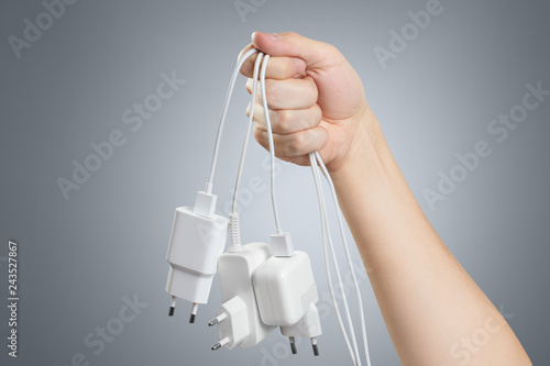 Hand holding white plugs on gray background